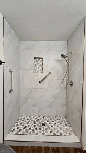 Walk-in shower remodel with marble-look tile and grab bars by Justus Bath in Edmond, Oklahoma