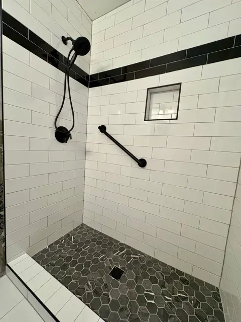 Stylish tiled walk-in shower featuring marble-look walls by Justus Bath in Norman, Oklahoma